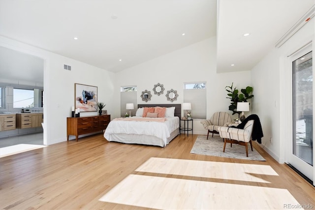 bedroom with multiple windows, high vaulted ceiling, access to outside, and light hardwood / wood-style floors