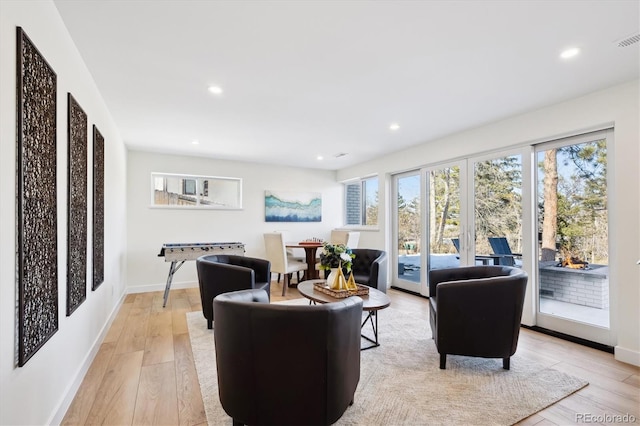 living room with french doors and light wood-type flooring