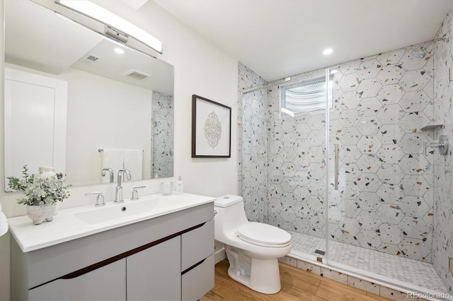 bathroom with vanity, toilet, a shower with door, and wood-type flooring