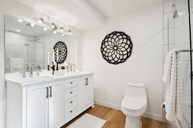 bathroom featuring vanity, hardwood / wood-style floors, a shower with shower door, and toilet