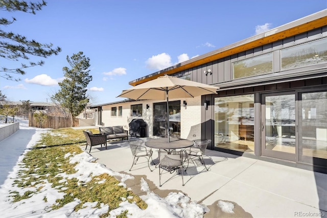 snow covered patio featuring an outdoor living space