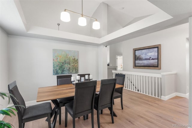 5332 S Lisbon Way, Centennial, CO 80015 - dining area with light wood-type flooring, a raised ceiling, and baseboards
