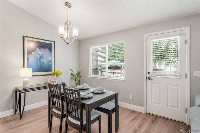5332 S Lisbon Way, Centennial, CO 80015 - dining room featuring light wood-style flooring, a chandelier, a textured ceiling, and baseboards