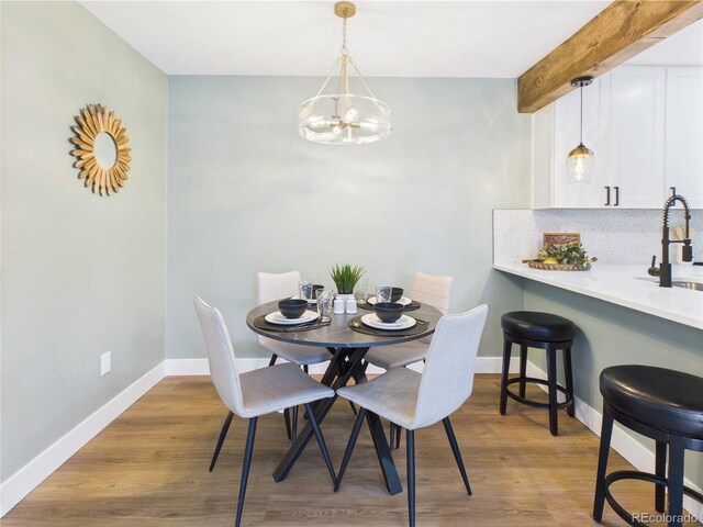 7205 S Gaylord St Unit G, Centennial, CO 80122 - dining area featuring a chandelier, baseboards, and wood finished floors