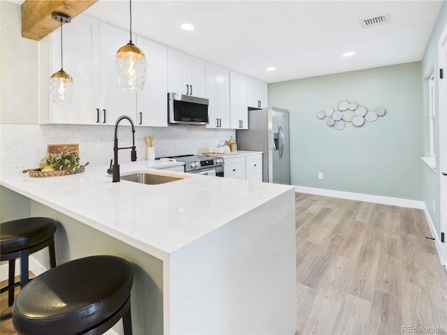 7205 S Gaylord St Unit G, Centennial, CO 80122 - kitchen with stainless steel appliances, a sink, a peninsula, decorative backsplash, and a kitchen breakfast bar