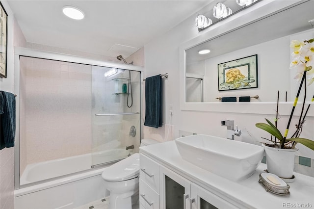 full bathroom featuring toilet, vanity, and bath / shower combo with glass door