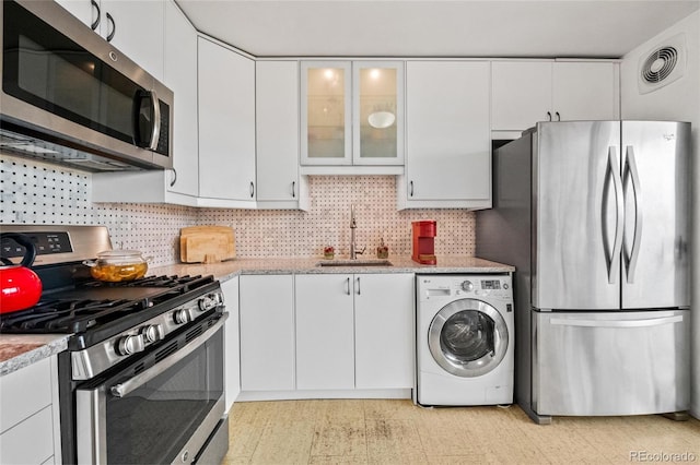 kitchen with sink, washer / clothes dryer, white cabinetry, and appliances with stainless steel finishes