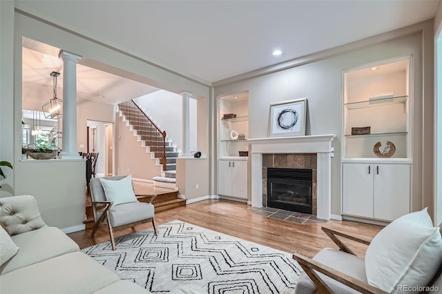 222 S Monroe St, Denver, CO 80209 - living area featuring decorative columns, wood finished floors, a fireplace, stairway, and baseboards