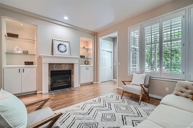 222 S Monroe St, Denver, CO 80209 - living room featuring built in shelves, light wood finished floors, baseboards, a tile fireplace, and recessed lighting