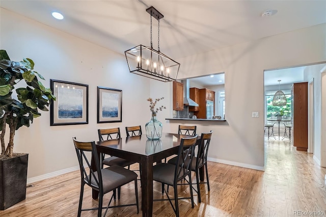 222 S Monroe St, Denver, CO 80209 - dining room featuring light wood finished floors, baseboards, and a chandelier