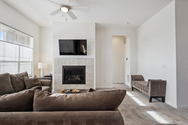 carpeted living room with a fireplace and ceiling fan