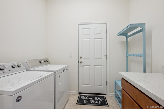 clothes washing area featuring washer and clothes dryer and light tile patterned flooring