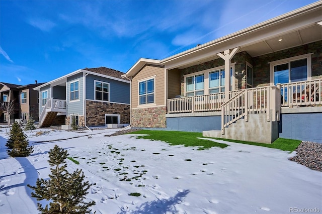 snow covered property with covered porch