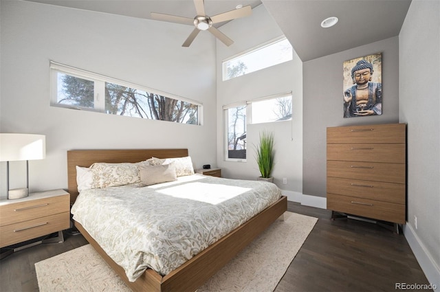 bedroom featuring baseboards, a high ceiling, ceiling fan, and dark wood-style flooring