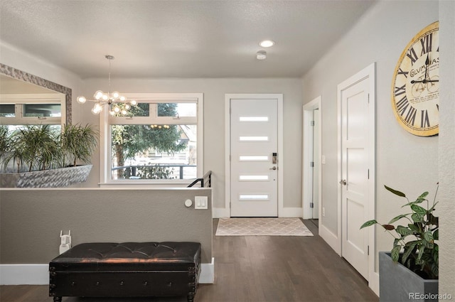 entryway featuring baseboards, dark wood-type flooring, and an inviting chandelier