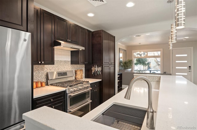 kitchen with visible vents, a sink, stainless steel appliances, light countertops, and under cabinet range hood