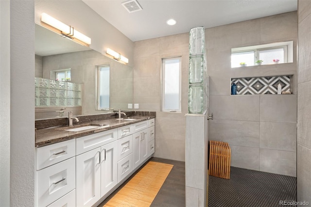 bathroom featuring plenty of natural light, radiator heating unit, visible vents, and a sink