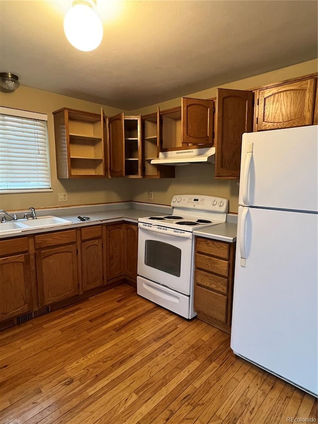 kitchen with sink, white appliances, and light wood-type flooring