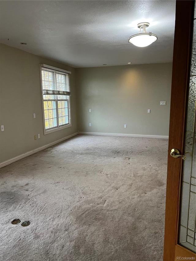 carpeted spare room featuring a textured ceiling