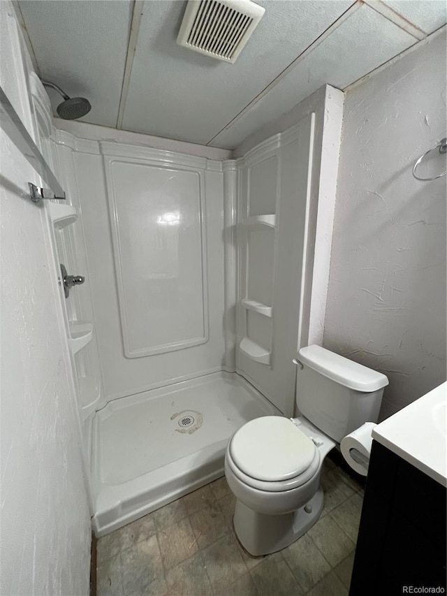 bathroom with walk in shower, vanity, and toilet