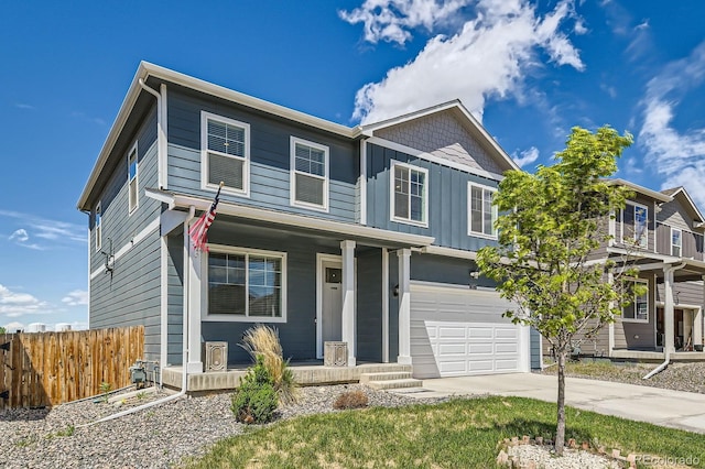 2417 Mountain Sky Dr, Fort Lupton, CO 80621 - view of front of home featuring covered porch, fence, a garage, driveway, and board and batten siding