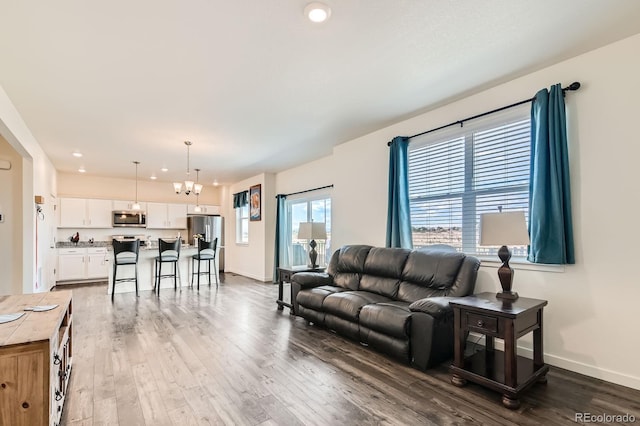 2417 Mountain Sky Dr, Fort Lupton, CO 80621 - living room featuring a chandelier, wood finished floors, baseboards, and recessed lighting