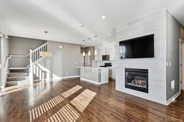 unfurnished living room featuring a tile fireplace and dark hardwood / wood-style floors