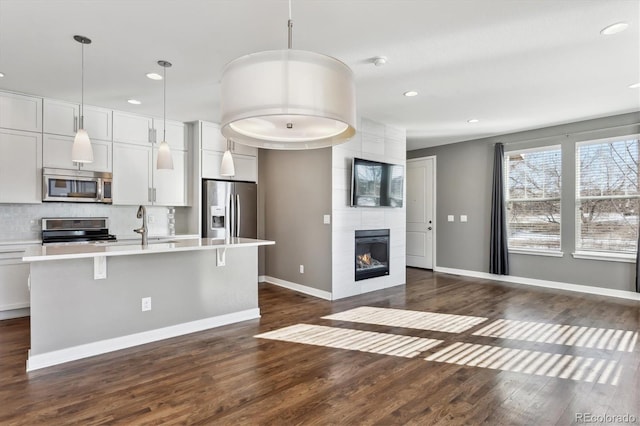 kitchen with white cabinetry, backsplash, decorative light fixtures, and appliances with stainless steel finishes