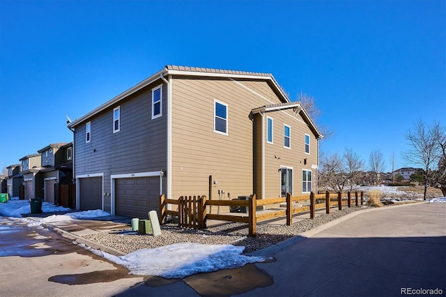 view of snow covered exterior featuring a garage