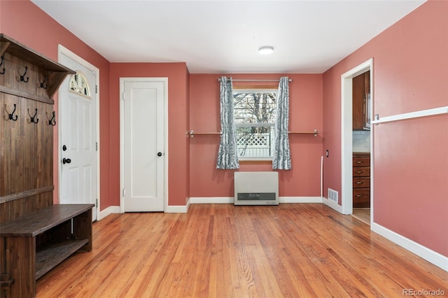 mudroom featuring heating unit, light wood-style floors, and baseboards