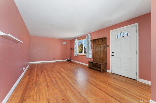 foyer with baseboards, visible vents, and light wood finished floors