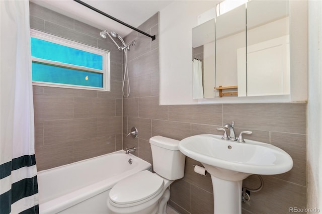 full bath with tasteful backsplash, shower / bath combo, toilet, and tile walls