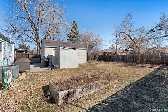 view of yard with an outbuilding, a shed, and a fenced backyard