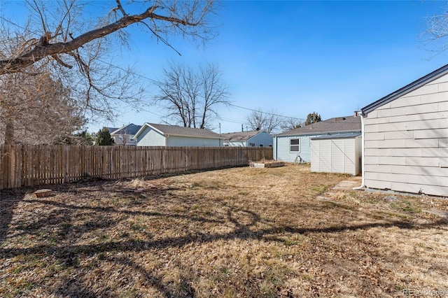 view of yard featuring a fenced backyard, an outdoor structure, and a shed