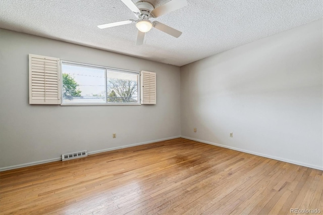 spare room featuring a textured ceiling, ceiling fan, and light wood-type flooring