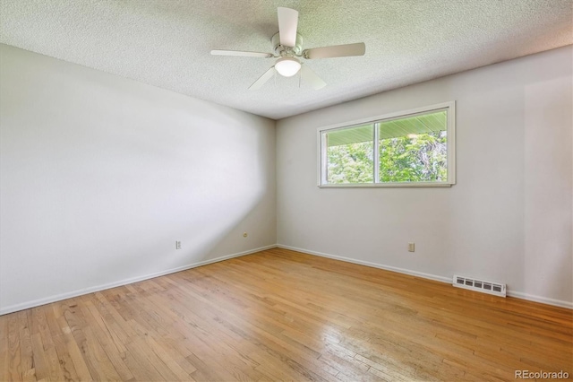 spare room featuring ceiling fan, light hardwood / wood-style floors, and a textured ceiling