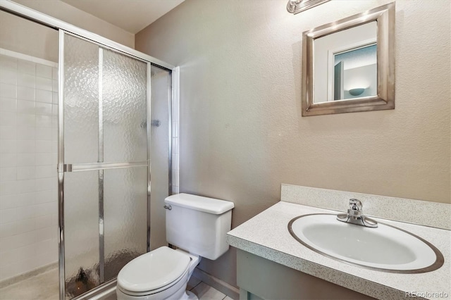 bathroom featuring a shower with door, toilet, and vanity