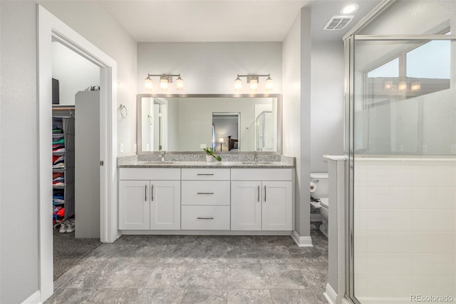 bathroom with visible vents, a sink, toilet, and double vanity