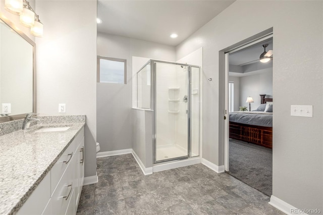 bathroom with toilet, vanity, baseboards, a stall shower, and ensuite bath