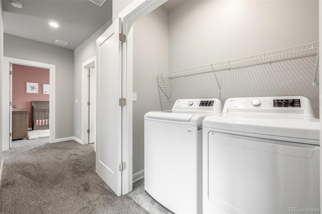 clothes washing area with light colored carpet, laundry area, visible vents, baseboards, and washer and dryer