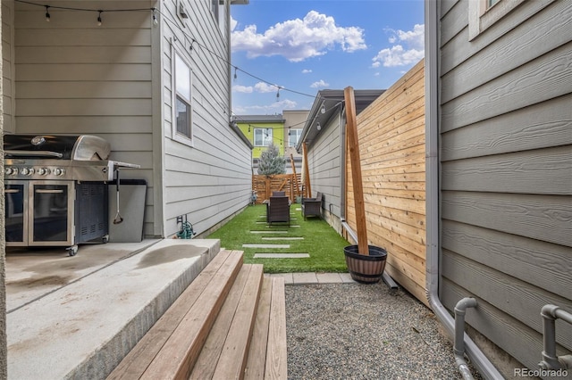 view of side of home featuring a lawn and fence