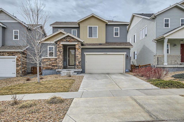 view of front of property with concrete driveway, a garage, stone siding, and board and batten siding