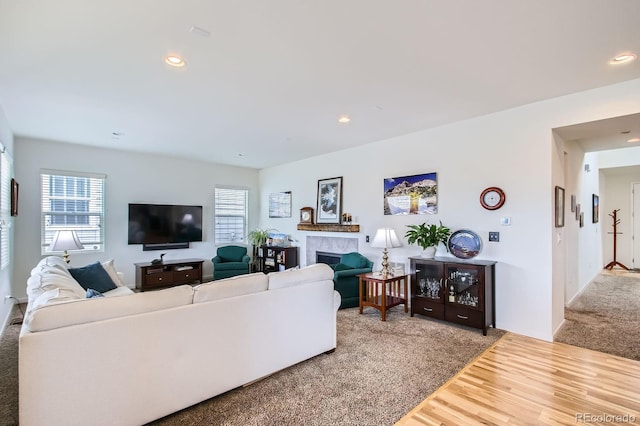 living area with recessed lighting, a fireplace, a healthy amount of sunlight, and carpet floors