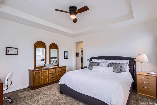 bedroom featuring carpet, a ceiling fan, baseboards, and a raised ceiling