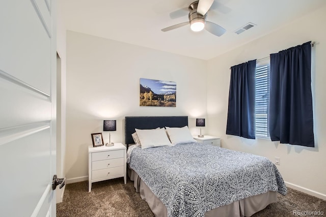 carpeted bedroom featuring baseboards, multiple windows, visible vents, and a ceiling fan