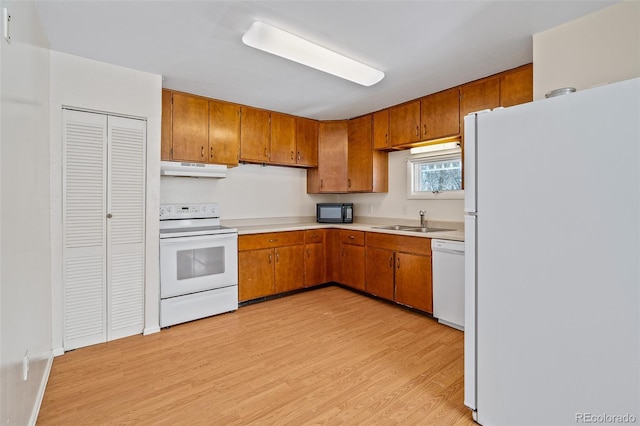 15071 County Road 306, Buena Vista, CO 81211 - kitchen with white appliances, under cabinet range hood, a sink, and brown cabinetry