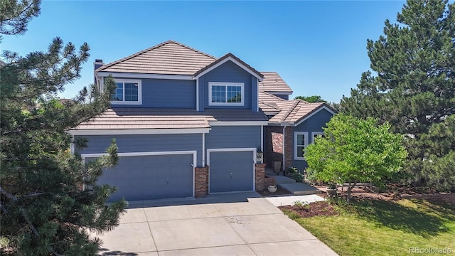 9992 Cottoncreek Dr, Highlands Ranch, CO 80130 - traditional-style house featuring an attached garage, concrete driveway, brick siding, a tiled roof, and a chimney