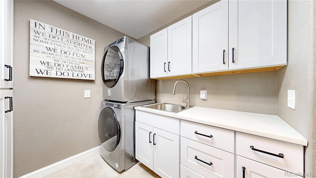 9992 Cottoncreek Dr, Highlands Ranch, CO 80130 - laundry area featuring stacked washer and clothes dryer, cabinet space, and light tile patterned floors