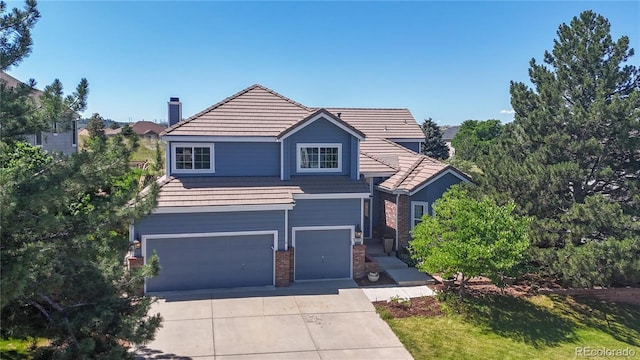 9992 Cottoncreek Dr, Highlands Ranch, CO 80130 - view of front facade with an attached garage, concrete driveway, a chimney, brick siding, and a tiled roof
