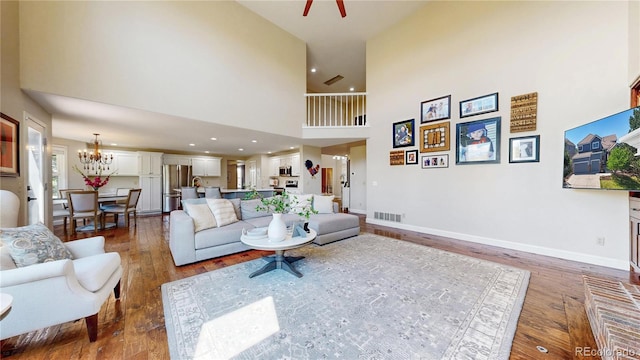 9992 Cottoncreek Dr, Highlands Ranch, CO 80130 - living area with a high ceiling, hardwood / wood-style floors, a chandelier, and recessed lighting